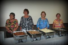 Members of both clubs serving the Saturday night dinner